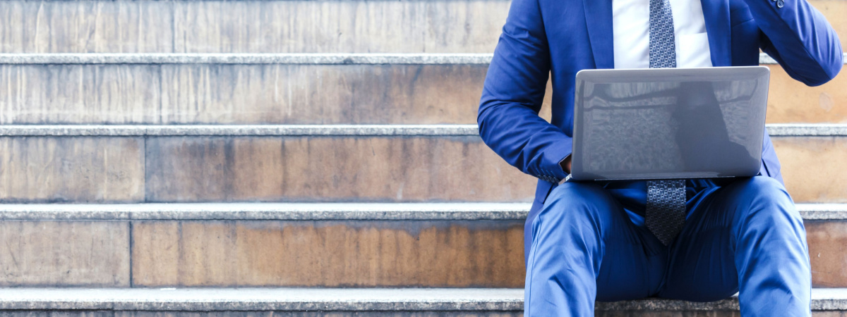 Businessman sitting on stairs and using laptop-independent contractor-gig worker economy-Shutterstock_701263531
